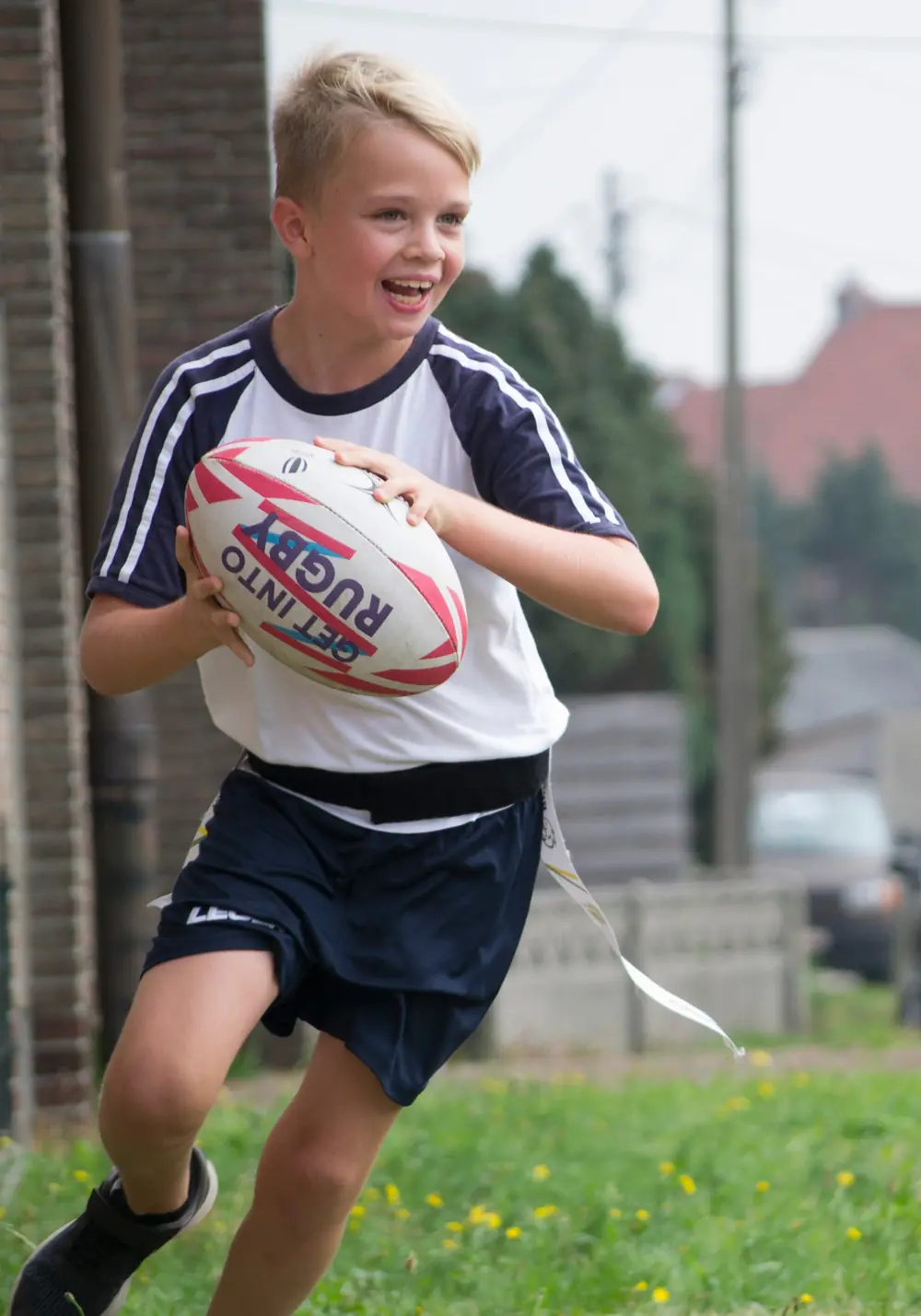 Kind met een rugbybal tijdens een initiatie