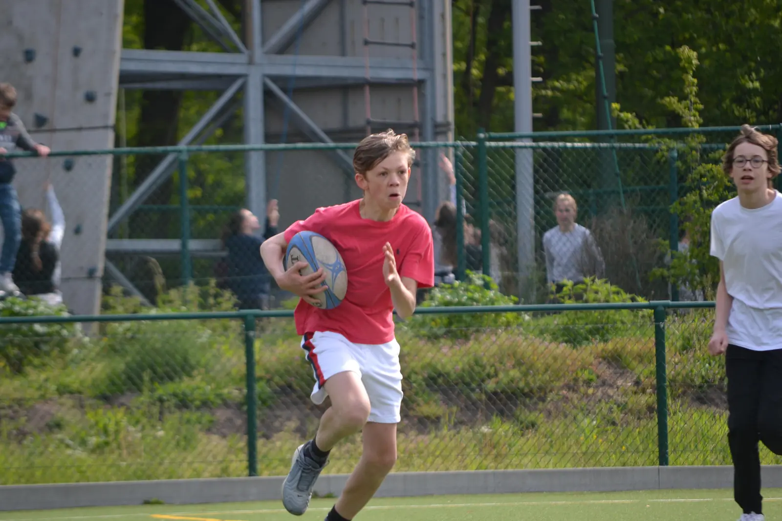 Kind loopt met een rugbybal tijdens een initiatie