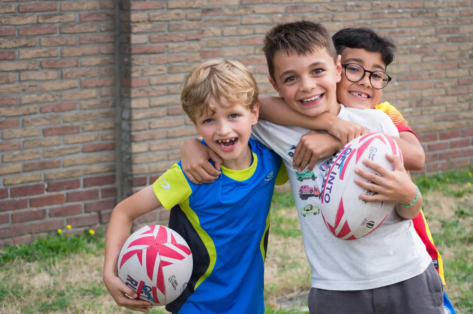 Twee lachende jeugdspelers met een rugbybal